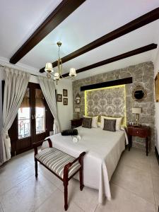 - une chambre avec un grand lit et un mur en pierre dans l'établissement Hotel Boutique Casa Veracruz, à Estepona