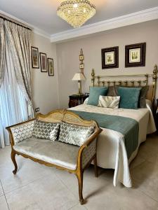 a bedroom with a bed and a couch and a chandelier at Hotel Boutique Casa Veracruz in Estepona