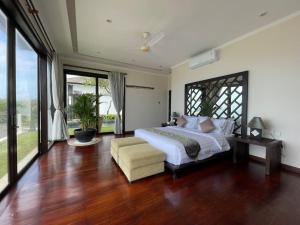 a bedroom with a large bed and a couch at Nusa Dua Ocean View 4 Bedroom Bibi Bali in Nusa Dua