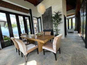 a dining room with a wooden table and chairs at Nusa Dua Ocean View 4 Bedroom Bibi Bali in Nusa Dua