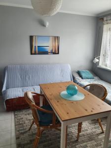 sala de estar con mesa de madera y sofá en Sztormowa 13, en Chałupy