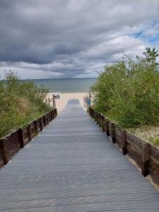 a boardwalk leading to the beach on a cloudy day at Sztormowa 13 in Chałupy