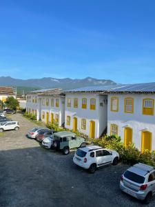 un grupo de autos estacionados en un estacionamiento frente a un edificio en Pousada Fortaleza, en Paraty