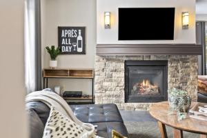 a living room with a fireplace with a tv above it at Blue Mountain Chalet Condo with Amazing Location in Blue Mountains