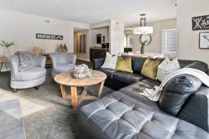 a living room with a black leather couch and a table at Blue Mountain Chalet Condo with Amazing Location in Blue Mountains