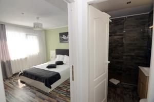 um quarto com uma cama e uma casa de banho com um chuveiro em Bunga Bunga Resort Mamaia Nord em Mamaia Nord – Năvodari