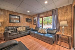 a living room with a leather couch and a television at James West Apt with 50 and Acres - Near Raystown Lake in Huntingdon