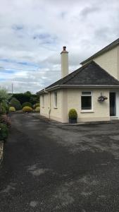 a white house with a driveway in front of it at ChestNut View Oldcastle 1 bed-room self catering in Oldcastle