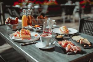 uma mesa coberta com pratos de comida e chávenas de café em Auberge des Gorges de la Diosaz em Servoz