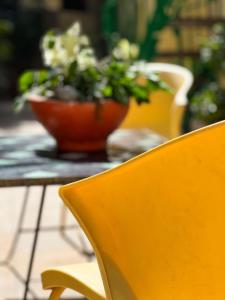 uma mesa com duas cadeiras e um vaso de flores em Hôtel Provençal em Dakar