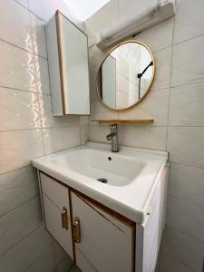 bagno con lavandino e specchio di Hôtel Provençal a Dakar