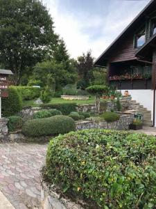 um jardim com um caminho de pedra e arbustos e um edifício em Apartment Monte Rosa em Delnice