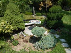 a garden with a bench in the middle of some bushes at Apartment Monte Rosa in Delnice