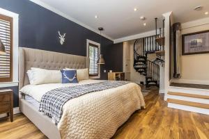 a bedroom with a large bed with a blue wall at Panoramic-Blue Mountain-Balcony-Sauna-Backyard-King in Blue Mountains