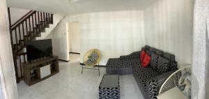 a living room with a couch and a television at Safia in Trou aux Biches