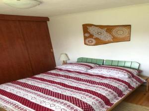 um quarto com uma cama com um edredão vermelho e branco em Apartment Monte Rosa em Delnice