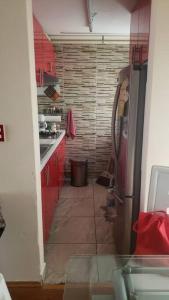 Super promoción departamento en la Cuauhtemoc في مدينة ميكسيكو: مطبخ صغير مع دواليب حمراء وثلاجة
