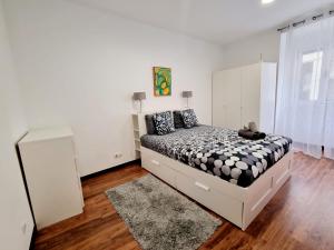 - une chambre blanche avec un lit et un tapis dans l'établissement Anjos Apartment - Ilha do Príncipe, à Lisbonne
