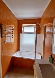uma casa de banho com uma banheira e uma janela em Anjos Apartment - Ilha do Príncipe em Lisboa