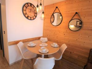 ein Esszimmer mit einem Tisch, Stühlen und einer Uhr in der Unterkunft Appartement Avoriaz, 2 pièces, 4 personnes - FR-1-633-32 in Avoriaz