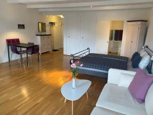un soggiorno con letto e tavolo con fiori di Joline private guest apartement Studio 45m2 a Nidau