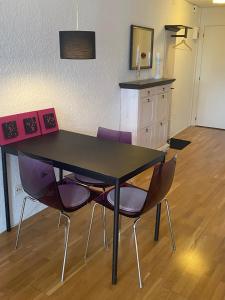a black table with purple chairs in a room at Joline private guest apartement Studio 45m2 in Nidau