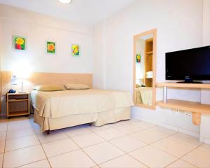 1 dormitorio con 1 cama y TV de pantalla plana en Ap 618 - Golden Dolphin Express, en Caldas Novas