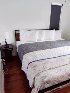 uma cama com almofadas brancas e um cobertor em Hillcrest Inn em Seaside