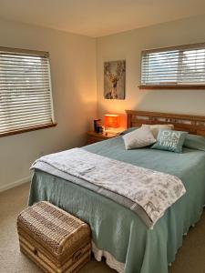 a bedroom with a large bed and two windows at Rudders Rest in Pacific City