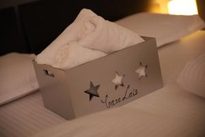 ブラショヴにあるCasa Laisのベッドの上にタオルを1箱用意しています。