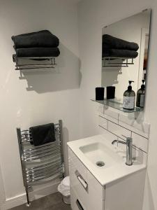 a white bathroom with a sink and a mirror at The Pod in Crowhurst