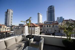 einen Balkon mit Sofas und Stadtblick in der Unterkunft Molcho Neve Tzedek in Tel Aviv