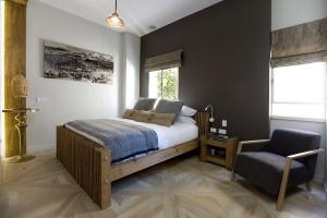 a bedroom with a bed and a chair at Molcho Neve Tzedek in Tel Aviv