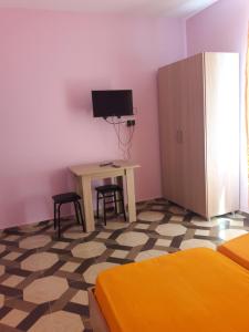 a bedroom with a bed and a desk with a computer at Giomari in Shekhvetili