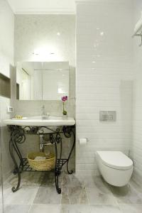 W łazience znajduje się umywalka, toaleta i lustro. w obiekcie Molcho Neve Tzedek w Tel Awiwie