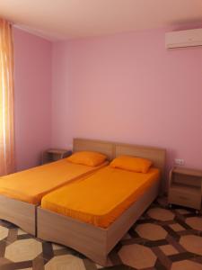 una camera con 2 letti e lenzuola arancioni di Giomari a Shekhvetili