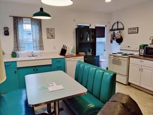 uma cozinha com armários azuis e uma mesa e cadeiras em Hillcrest Inn em Seaside