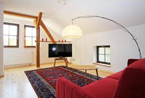 Una sala de estar con un sofá rojo y un televisor. en Naturerlebnis, en Malchin