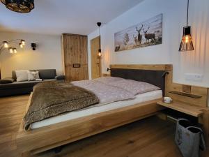 a bedroom with a wooden bed and a couch at Landhaus Schatz in Nesselwängle