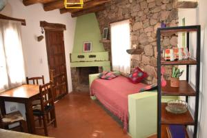 a bedroom with a bed and a stone wall at Cabañas La rueda in Tilcara