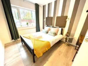 um quarto com uma cama com um cobertor amarelo e uma janela em Serene and Cozy 1-Bedroom House with Parking em Cambridge