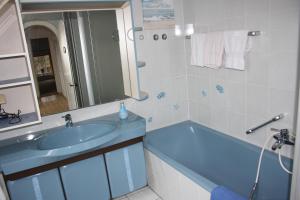 uma casa de banho com um lavatório, uma banheira e um espelho. em Ferienwohnungen Manfred Peters Baven em Hermannsburg