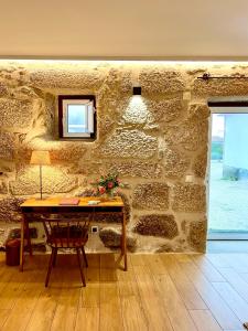 a stone wall with a table and a window at Quinta da Porta - Solar de Vale de Prazeres in Vale de Prazeres