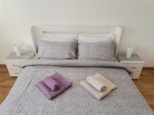 a bed with two towels and two pillows on it at MDM Apartman Vrnjačka Banja in Vrnjačka Banja