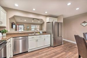 a kitchen with white cabinets and a stainless steel refrigerator at Gorgeous Bentonville Vacation Rental! in Bentonville