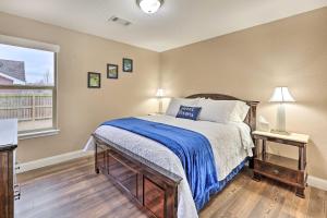 a bedroom with a bed with a blue blanket and a window at Gorgeous Bentonville Vacation Rental! in Bentonville