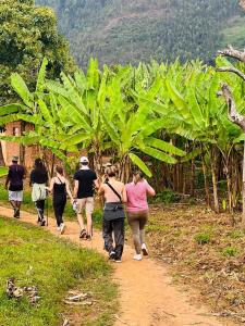 a group of people walking down a dirt path in a field at Twin Lakes Recreational Island in Ryandinzi
