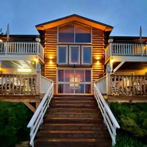 a log home with stairs leading to the front door at Vibe Naftali Estate in Ramot Naftali