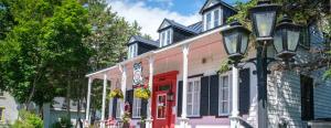 una casa colorida con una luz de la calle delante de ella en Om Chalet 3 avec spa et accès au fleuve, en Saint-Laurent-de-l'ile d'Orleans