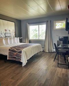 1 dormitorio con cama, escritorio y ventana en Valued Stay Aloha, en Madison